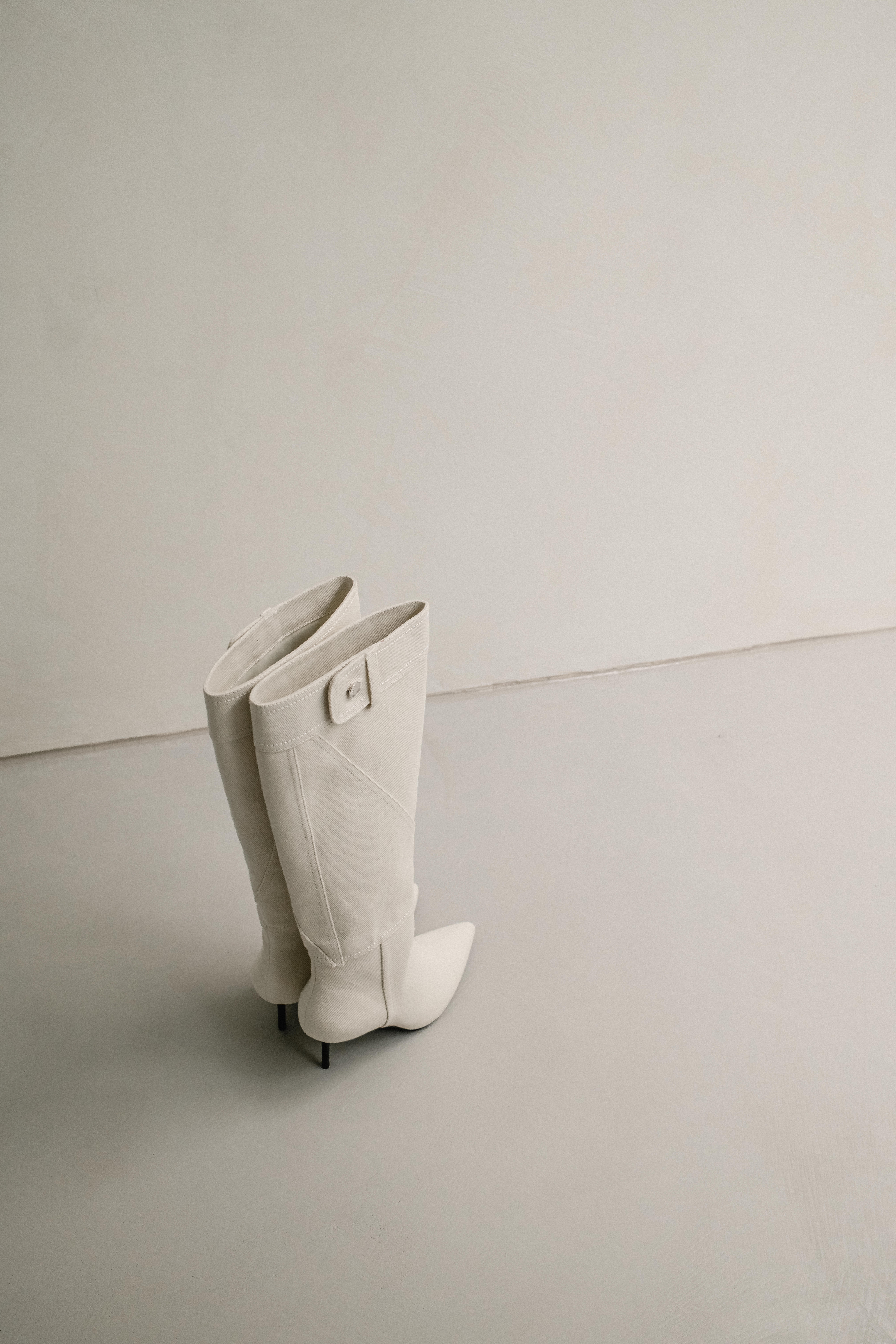A minimal still life of boots and dark feminine outfit pieces