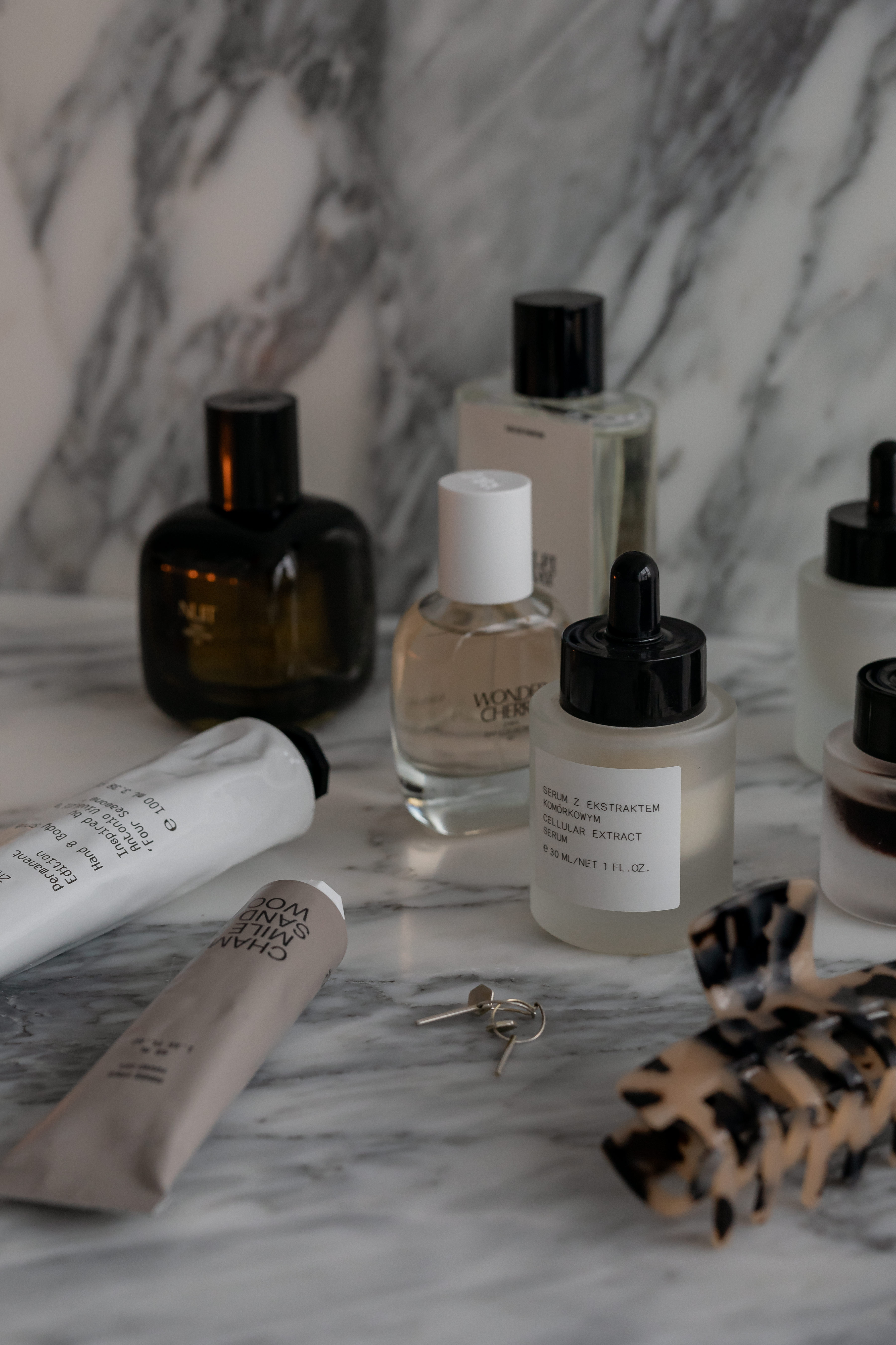 Serums and perfume bottles arranged on marble