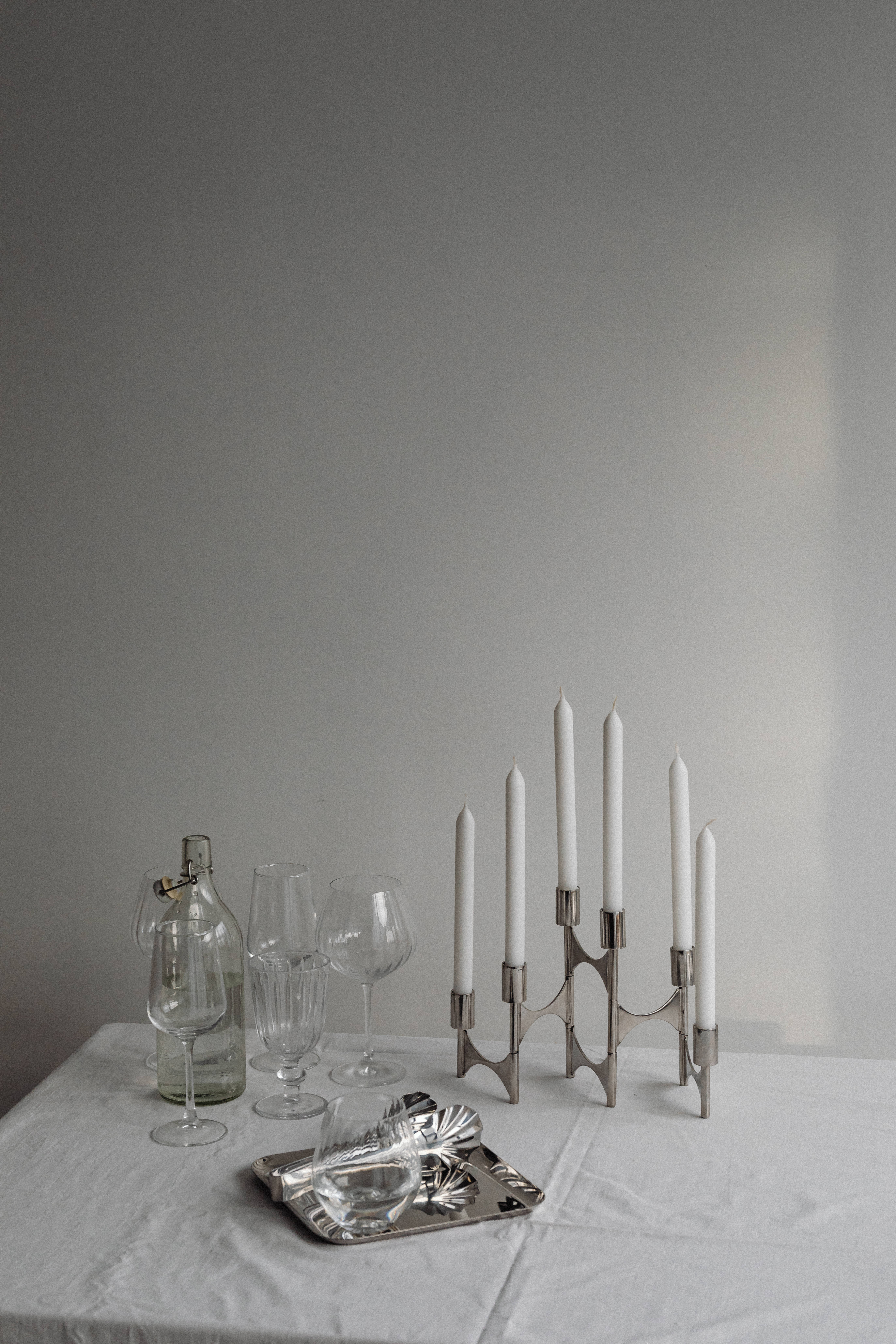 Taper candles and wine glasses set on linen